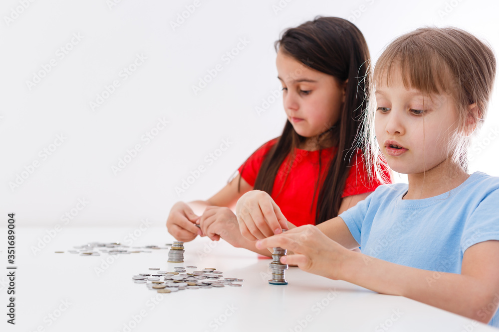 portrait of little girls sitting at table and calculating money portrait of little girls sitting at table and calculating money