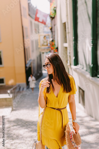 fashion woman wearing summer dress and sunglasses walk in street outdoors