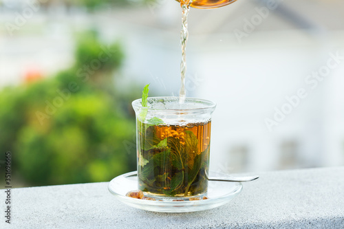 Glass of hot mint tea, traditional moroccan moorish beverage photo