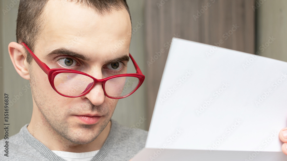 Guy with glasses is reading a letter intently, portrait, closeup, toned Guy with glasses is reading a letter intently, portrait, closeup, toned