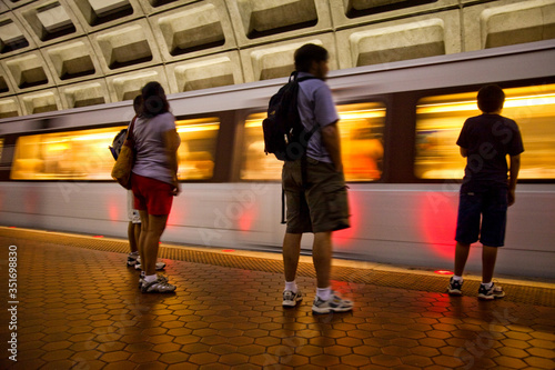 people standing in subway waiting for train to stop as it rushes by © Dennis M. Swanson