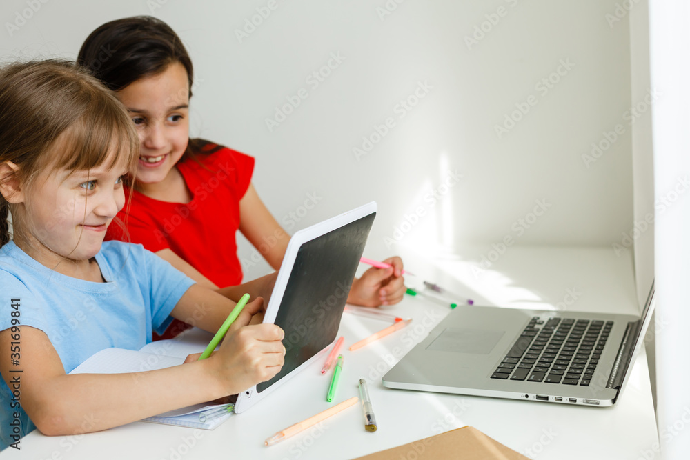 Pretty stylish schoolgirls studying during her online lesson at home, social distance during quarantine, self-isolation, online education concept Pretty stylish schoolgirls studying during her online lesson at home, social distance during quarantine, self-isolation, online education concept