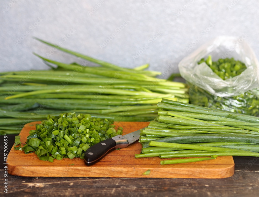 Harvesting,storage, and freezing of vegetables and fruits.The process of cutting onions on a dark table and packing them in plastic bags. Harvesting,storage, and freezing of vegetables and fruits.The process of cutting onions on a dark table and packing them in plastic bags.