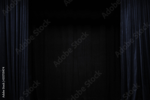 Fotografie Very dark blue velvet curtain on the sides of a black theatre stage, background