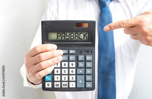 Fotografie PAYBACK word text inscription on Calculator in hands of a businessman