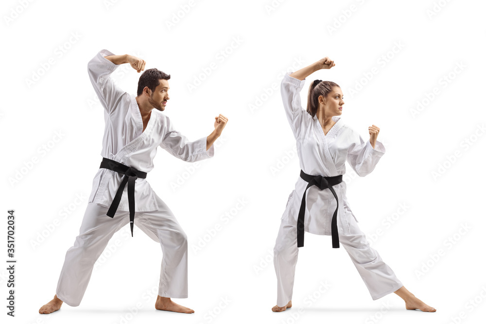 Full length shot of a young man and woman with black belts practicing karate