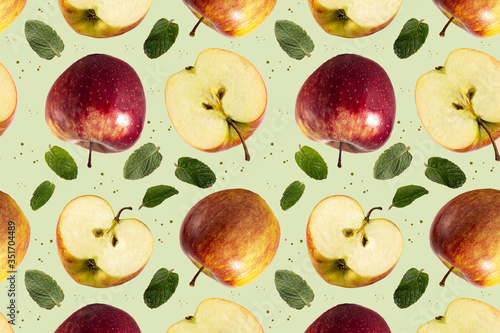 Fototapeta Naklejka Na Ścianę i Meble -  Seamless pattern of red apples, fruit slices and mint leaves on a green background. The texture of the food.