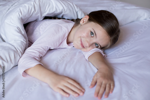 Cute little girl in bed woke up in the morning