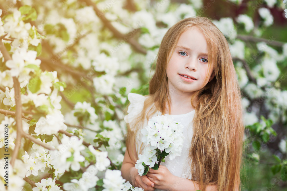 Beautiful preteen girl with long blond hair enjoy spring apple blooming. Little preschool girl in garden tree flowers. Copy space for text. Beautiful preteen girl with long blond hair enjoy spring apple blooming. Little preschool girl in garden tree flowers. Copy space for text.