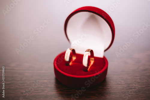 wedding golden rings in red box on wooden background close-up © Irina