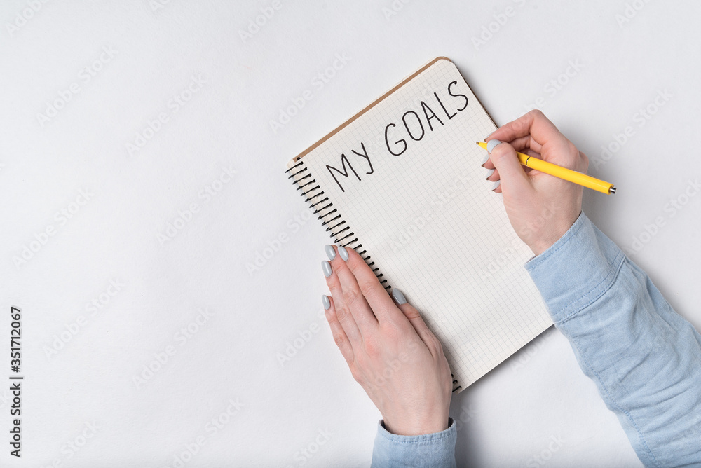 Female hand written Inscription MY GOALS in notebook. Close up. Female hand written Inscription MY GOALS in notebook. Close up.