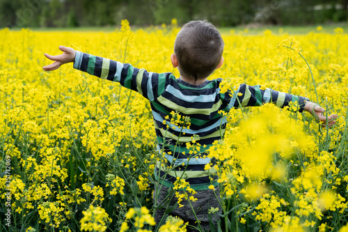 Szczęśliwy chłopiec na żółtym polu rzepaku w Polsce