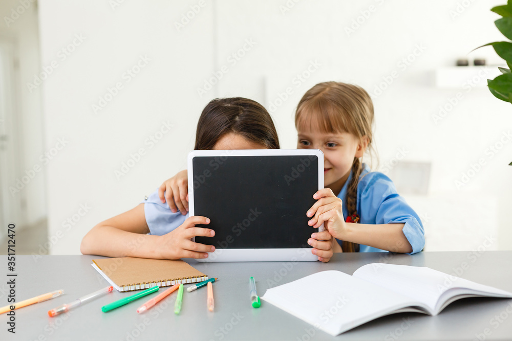 Pretty stylish schoolgirls studying during her online lesson at home, social distance during quarantine, self-isolation, online education concept Pretty stylish schoolgirls studying during her online lesson at home, social distance during quarantine, self-isolation, online education concept