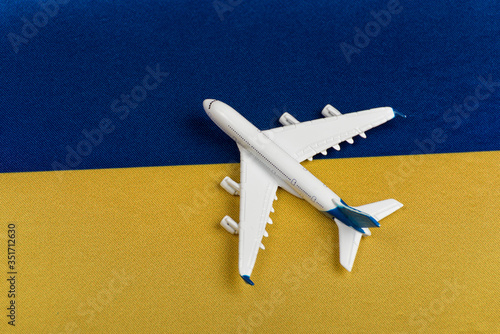 Flag of Ukraine and model airplane. Resumption of flights after quarantine, opening borders. Travel to Ukraine