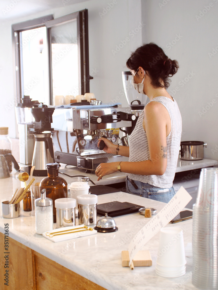 young barista girl in medical mask with city cafe background young barista girl in medical mask with city cafe background