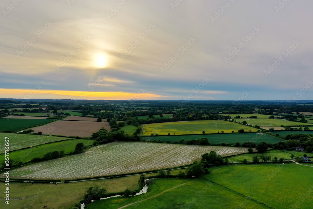beautiful sunset of British landscape showing patchwork fields and hills in the distance 