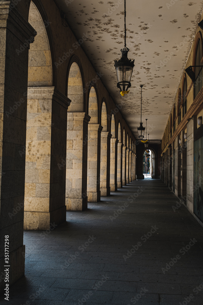 Outdoor corridor with tall arch in a building detail in Girona, Catalonia