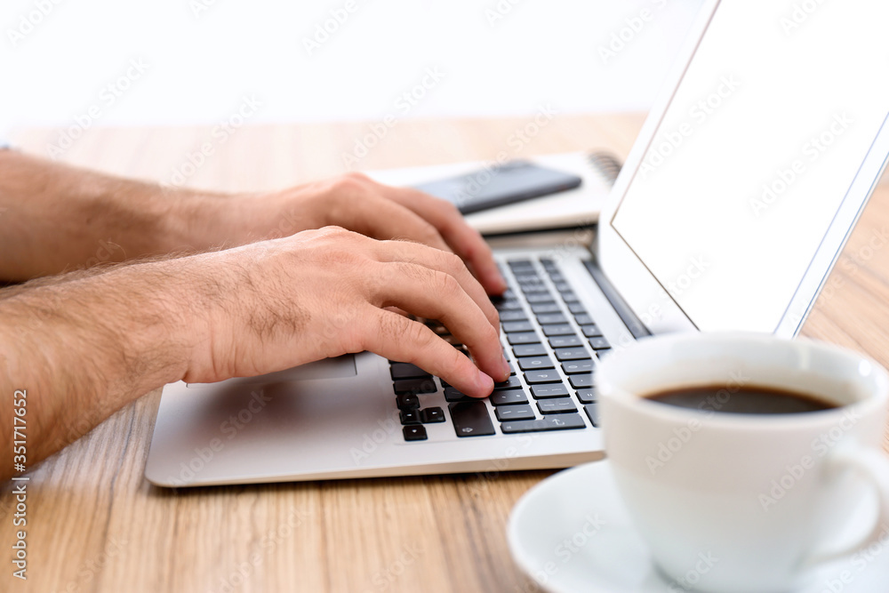 Man working with modern laptop at wooden table, closeup Man working with modern laptop at wooden table, closeup