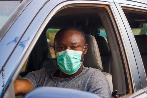 young black man wearing a nose mask and driving his car