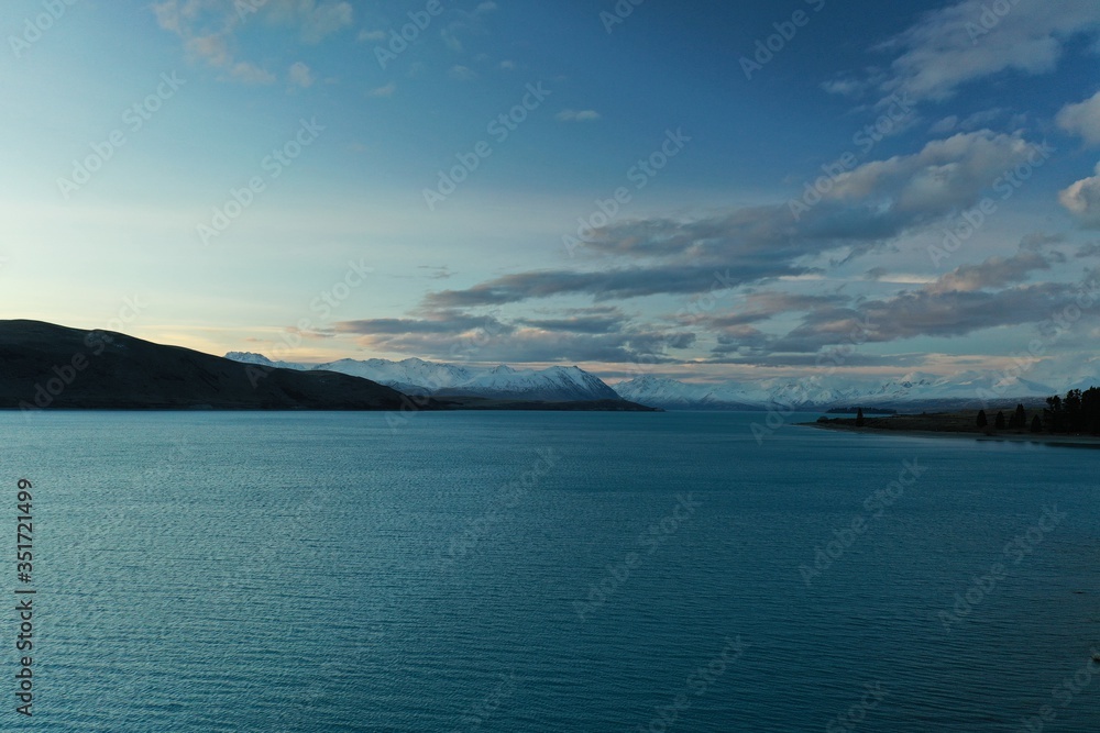 Aerial photograph over vast blue lake with mountains in the distance. South Island, New Zealand.