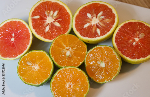 Beautiful lemons and grapefruits cut in half on a cutting board.