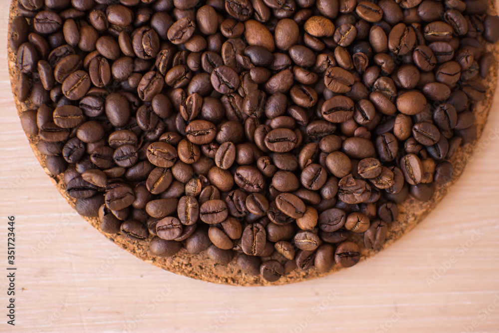 Fototapeta premium brown coffee beans on a wooden background and cork stand