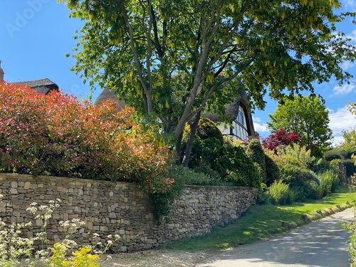 old stone wall concealing cottage in Emley Castle with colourful trees in the cotswolds
