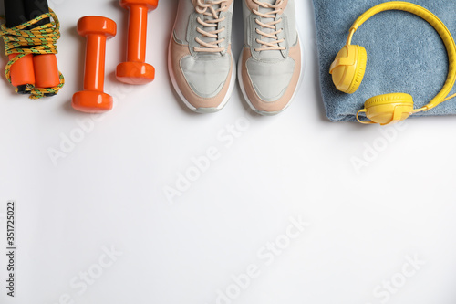 Flat lay composition with fitness equipment and headphones on white background. Space for text © New Africa
