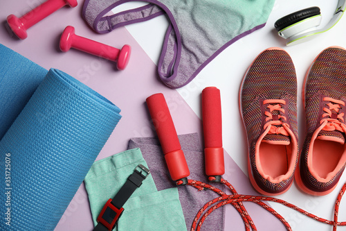 Flat lay composition with fitness equipment on color background