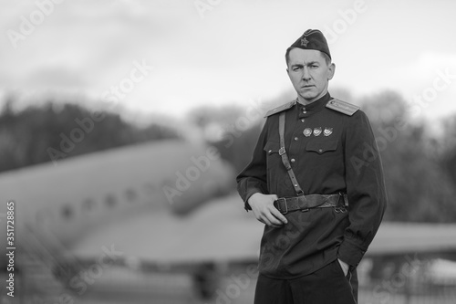 Retro style black and white photography. A young adult male pilot in the Military uniform of pilots of the Soviet Army of the World War II period. photo