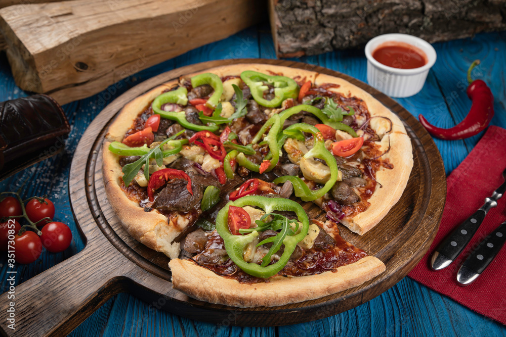 Italian pizza with meat on blue background Italian pizza with meat on blue background