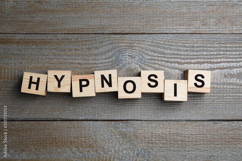 Fototapeta premium Blocks with word HYPNOSIS on wooden background, flat lay