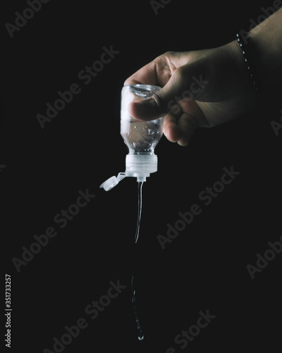 male hand throwing hands sanitizer on black background