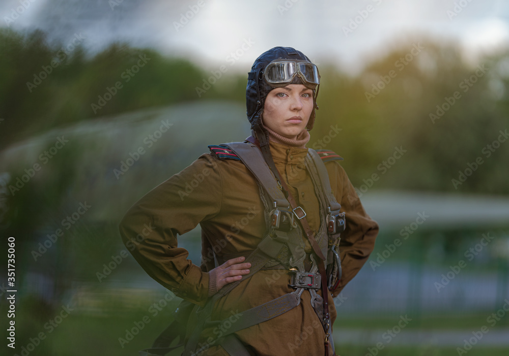A young female pilot in uniform of Soviet Army pilots during the World War  II. Military shirt with shoulder straps of a major, parachute, flight  helmet and goggles. Stock Photo | Adobe