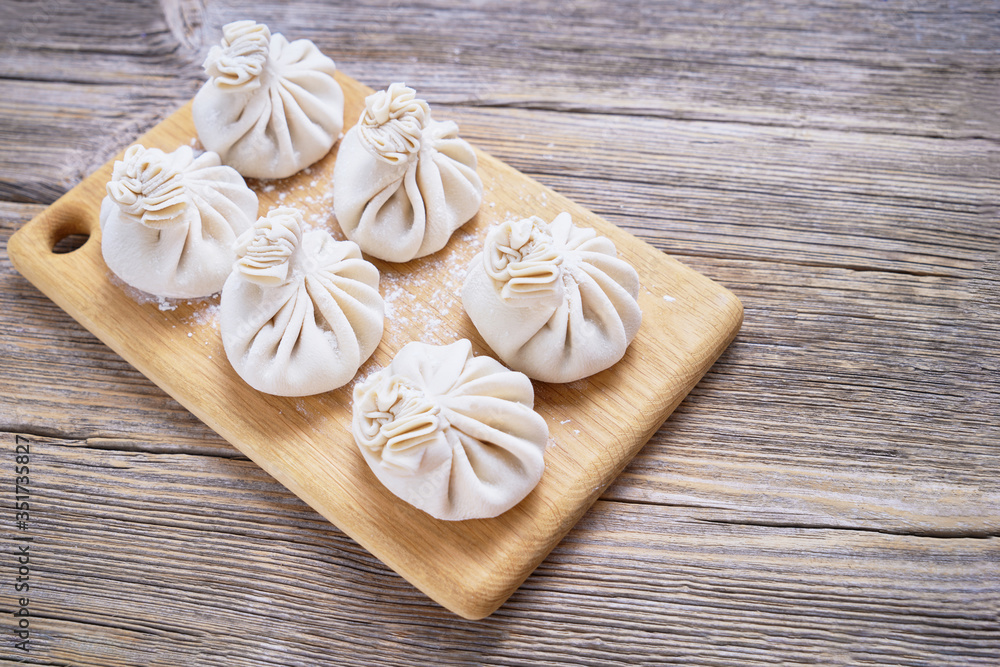 Georgian dumpling or Khinkali. Georgian homemade khinkali on cutting board. Top view, copy space Georgian dumpling or Khinkali. Georgian homemade khinkali on cutting board. Top view, copy space