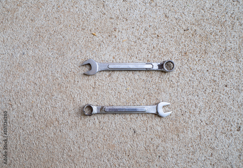 A small steel wrench with cement ground A small steel wrench with cement ground