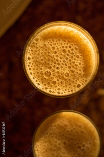 Glass with whipped milk in blender making bubbles