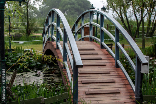Fotografia, Obraz Arch Footbridge Over Stream In Park