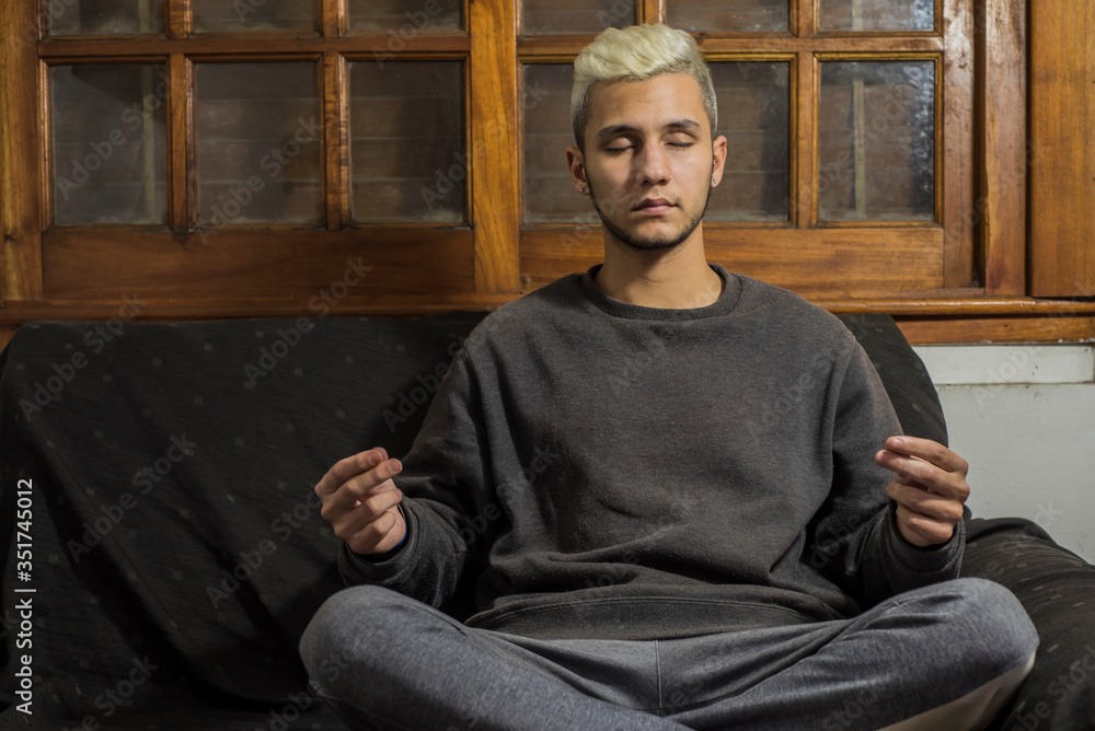 young man quarantined by coronavirus strengthening his mental health through meditation and relaxation at home
young man quarantined by coronavirus strengthening his mental health through meditation and relaxation at home