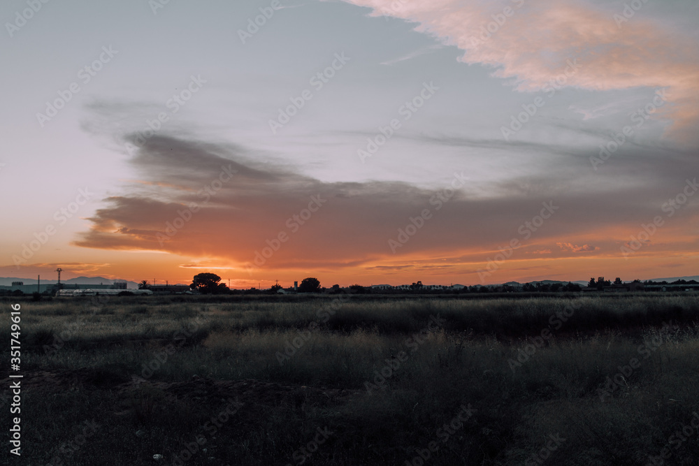 Obraz premium Natural Sunset Sunrise Over Field Or Meadow. Bright Dramatic Sky And Dark Ground. Countryside Landscape Under Scenic Colorful Sky At Sunset Dawn Sunrise. Sun Over Skyline, Horizon. Warm Colours.