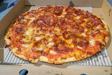 Greasy takeout Pepperoni pizza in carboard box