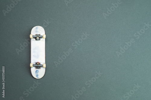 Small skateboard on color background. tiny skate for fingers. fingerboard close up photo