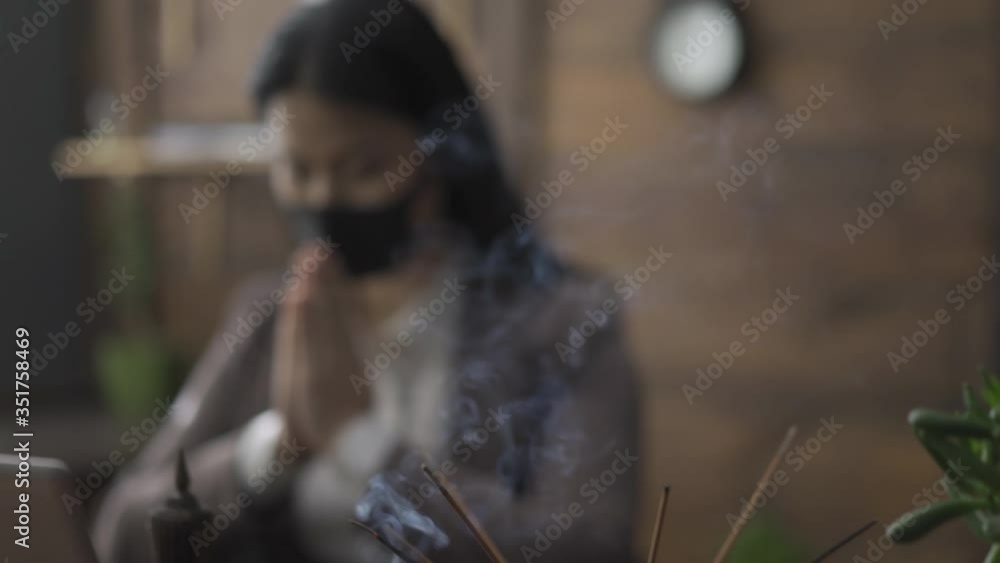 Asian businesswoman is praying in sitting at a modern office table with decorative wooden walls. Focus on the first subject, blur on the background. Camera slide on woman. Prores 422. Asian businesswoman is praying in sitting at a modern office table with decorative wooden walls. Focus on the first subject, blur on the background. Camera slide on woman. Prores 422.
