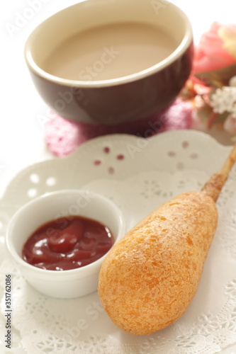 Corn dog and ketchup on dish for fast food