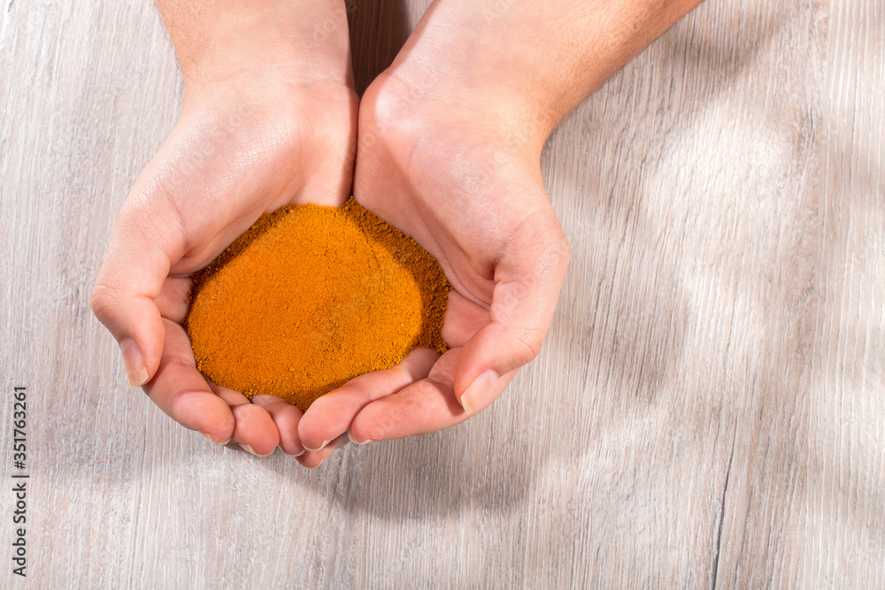 Curcuma longa - Female hands holding turmeric powder