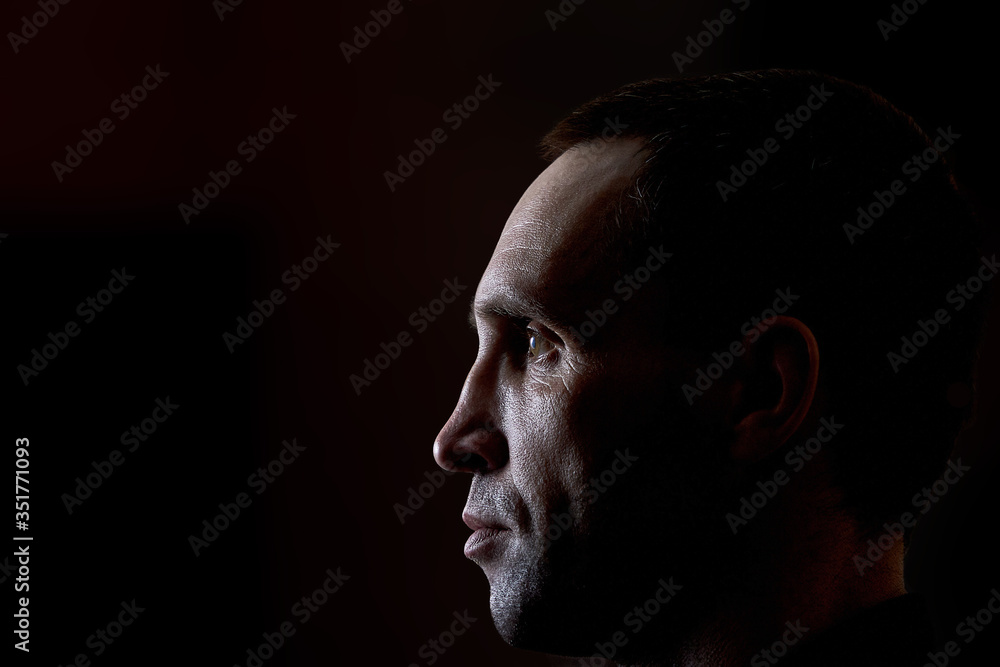 Brutal man in a black shirt on a dark background Brutal man in a black shirt on a dark background