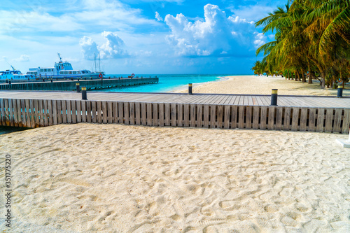 Wooden bridges leading to the huts on the shores of the tropical  warm sea. Maldives. Tourism concept.