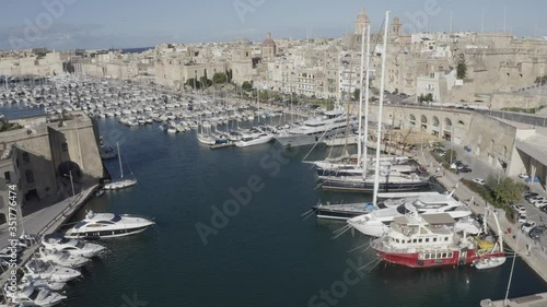 Aerial view of sailboats moored in harbour Senglea and Birgu, Bormla / Cospicua, Valletta, Malta. Ancient architecture of old town: christian orthodox churches, cathedrals, basilicas. Sunny day, blue  photo