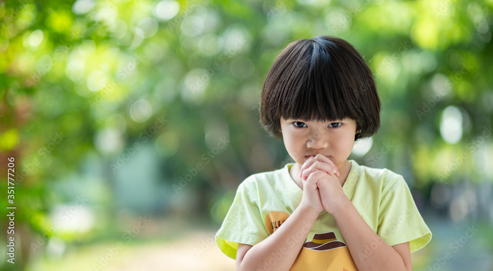 kid praying in morning, hands folded in prayer
