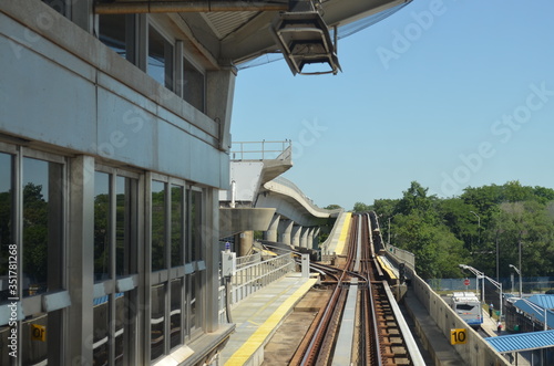 Estación moderna de tren. Rieles modernos. Vista de un bosque al fondo en un día soleado.